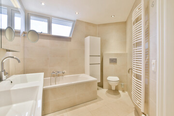Stylish bathroom featuring a modern tub, sleek fixtures, and natural light streaming through the windows, creating a serene atmosphere.