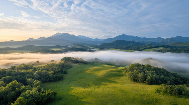 Golden morning rays illuminate misty mountain landscape, showcasing lush greenery and rolling