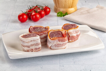Raw pork tenferloin with bacon