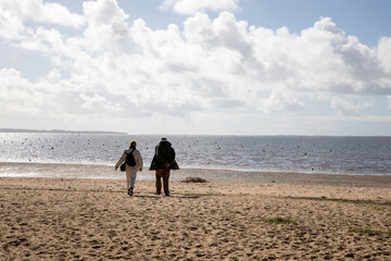 senior couple retirement people walking along sea wild coast beach