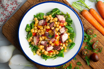 Salpicon de pulpo. Octopus salad with chickpeas, arugula and vegetables. Top view table.