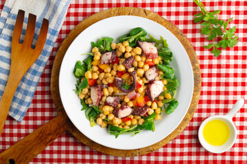 Salpicon de pulpo. Octopus salad with chickpeas, arugula and vegetables. Top view table.