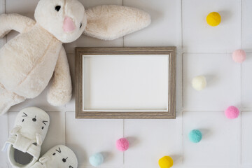 Baby shower invitation with a blank photo frame and soft decorations
