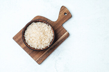 Rice serves as a staple food on a brown wooden cutting board