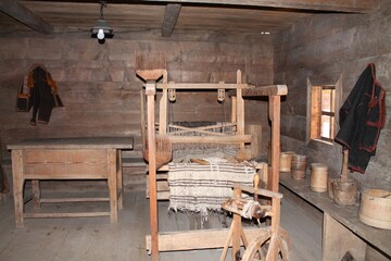 Exploration of a rustic traditional weaver's workshop nestled in the heart of the countryside, showcasing simple tools and crafts in a serene wooden setting