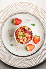 Individual baked strawberry crumble. Top view table.