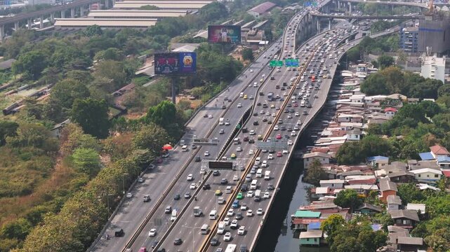 Aerial tilt motion view of Bangkok Sirat Expressway with many cars during rush hour in the day time