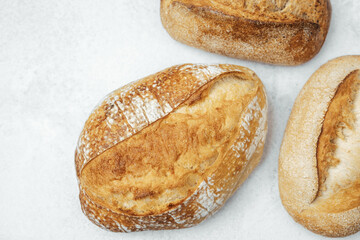 Freshly baked artisan bread loaves on a light surface ready for serving