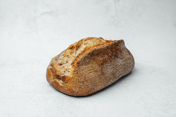 Freshly baked bread loaf resting on a light textured background