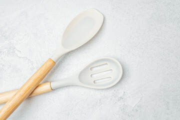 Sleek modern cooking utensils arranged on a light gray surface