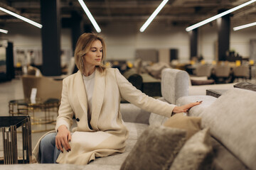 Woman in a Furniture Store Choosing a Modern and Stylish Sofa
