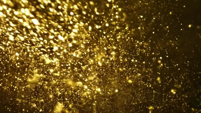 Falling Gold Particles Flicker And Shimmer Against A Black Background
