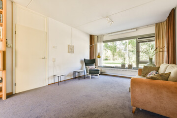 An inviting, modern living room featuring comfortable seating, large windows with natural light,...