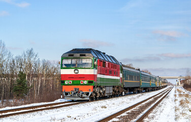 Belarusian locomotive with a Russian train in winter in Ukraine