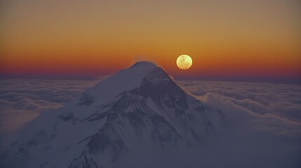 Fototapeta premium Majestic mountain peak above clouds at sunrise/sunset