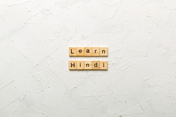 Learn Hindi word written on wood block. Learn Hindi text on table, concept