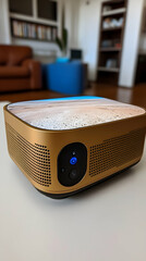 Golden device with beach view on top sits on a table