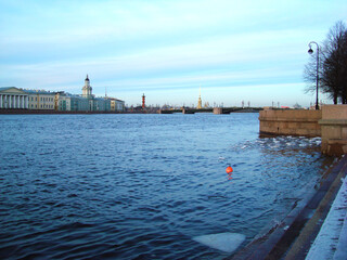 Winter scene of neva river with icy shoreline and city buildings