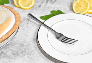 Lemon meringue pie with sliced lemons and mint