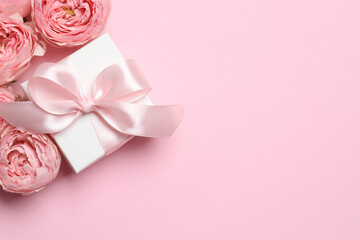 Beautiful pink peony roses with gift box on pink background