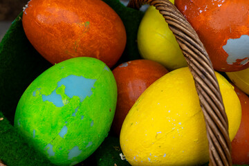 Colorful eggs nestled in a woven basket ready for an exciting springtime egg hunt at a local park celebration