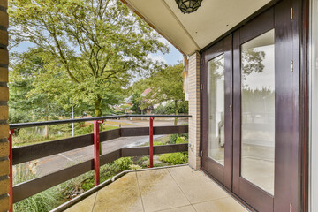 A serene view from a modern balcony showcasing lush green trees and a spacious layout. Natural light enhances the inviting atmosphere of the space.