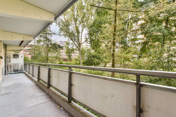 A contemporary balcony space showcasing a view of lush greenery, designed for relaxation and outdoor enjoyment. Ideal for urban settings.