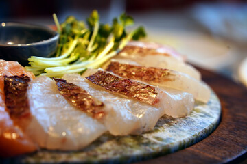 A beautifully arranged plate of fresh sashimi with garnishes.