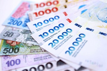 Argentine pesos money bills in big amount lies on white table close up