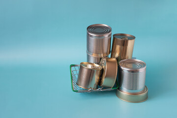 A set of cans with various products in close-up on a colored kopi space background. Long-term storage products.