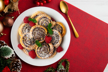 Puff pastry rolls filled with Nutella and pistachios. Top view table with christmas decorations.