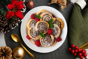 Puff pastry rolls filled with Nutella and pistachios. Top view table with christmas decorations.