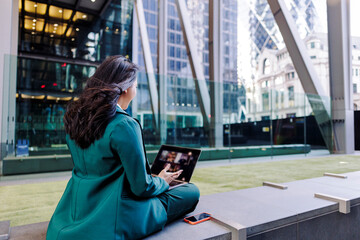 Businesswoman sitting in the city having a viedeo conference
