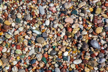Small sea stones, gravel. Background. Textures. Pebbles on the beach