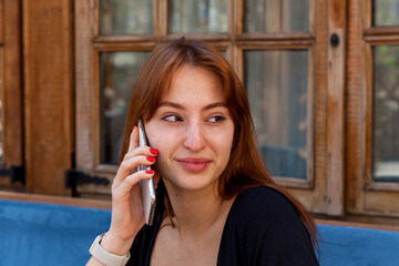 Smiling woman talking on smartphone at cozy cafe