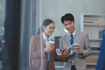 Successful young business people talking, working together in front of modern business building
