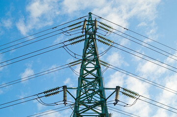 power transmission line support and wires against blue sky close-up