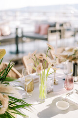 Bouquet of flowers stands on a served table among glasses