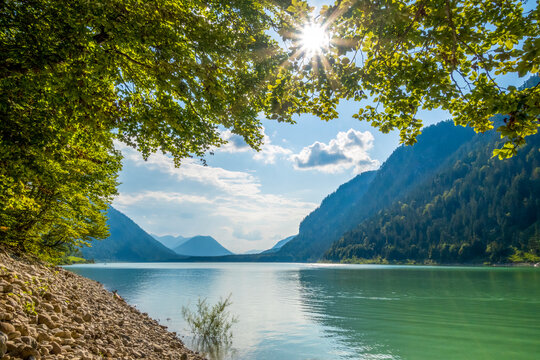 Scenic view of Lake Sylvenstein with sunrays and atmospheric lighting in Bavaria, Germany.