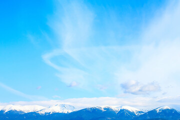Mountains peaks and cloudy sky background