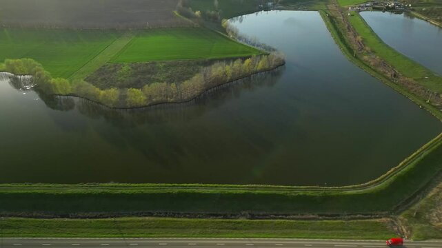 Vibrant green landscape around peaceful Rai Pond (Iaz Rai) in Botosani, Romania