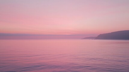 Obraz premium A pastel pink sky during sunrise over the ocean