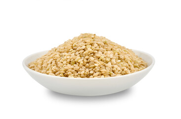 closeup dry brown short grain unpolished rice or Japanese brown rice in white ceramic bowl cutout