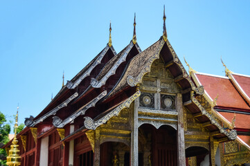 Naklejka premium Golden Pagoda and Chapel, Lanna Architecture, Symbols of Buddhism, South East Asia at Wat Phra Singh Woramahaviharn, Chiang Mai, Northern Thailand