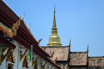Fototapeta premium Golden Pagoda and Chapel, Lanna Architecture, Symbols of Buddhism, South East Asia at Wat Phra Singh Woramahaviharn, Chiang Mai, Northern Thailand
