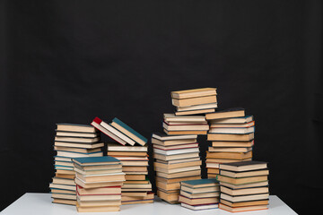 Stacks of old books for studying in the library on a black background of the university