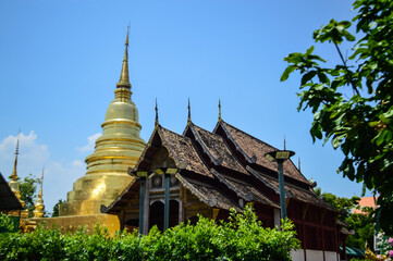 Naklejka premium Golden Pagoda and Chapel, Lanna Architecture, Symbols of Buddhism, South East Asia at Wat Phra Singh Woramahaviharn, Chiang Mai, Northern Thailand