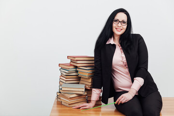 Woman teacher in suit and table with stacks of library books