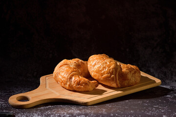 Rustic Croissants homemade morning dayly breakfast on dark wall texture with copy space.