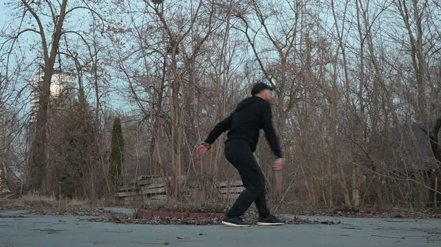 A man with a wooden racket playing sansibar in a forest, ideal for outdoor, sports, and nature themes.